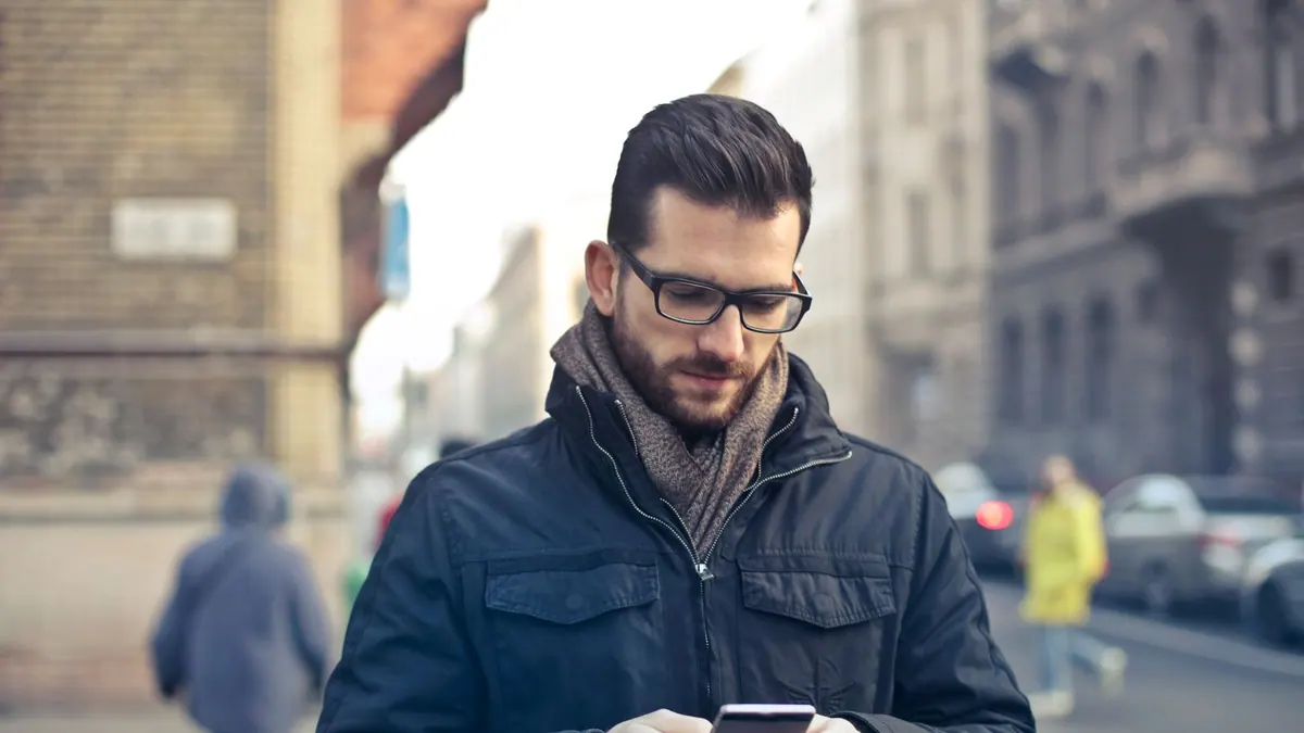 Man checking his phone on a city street