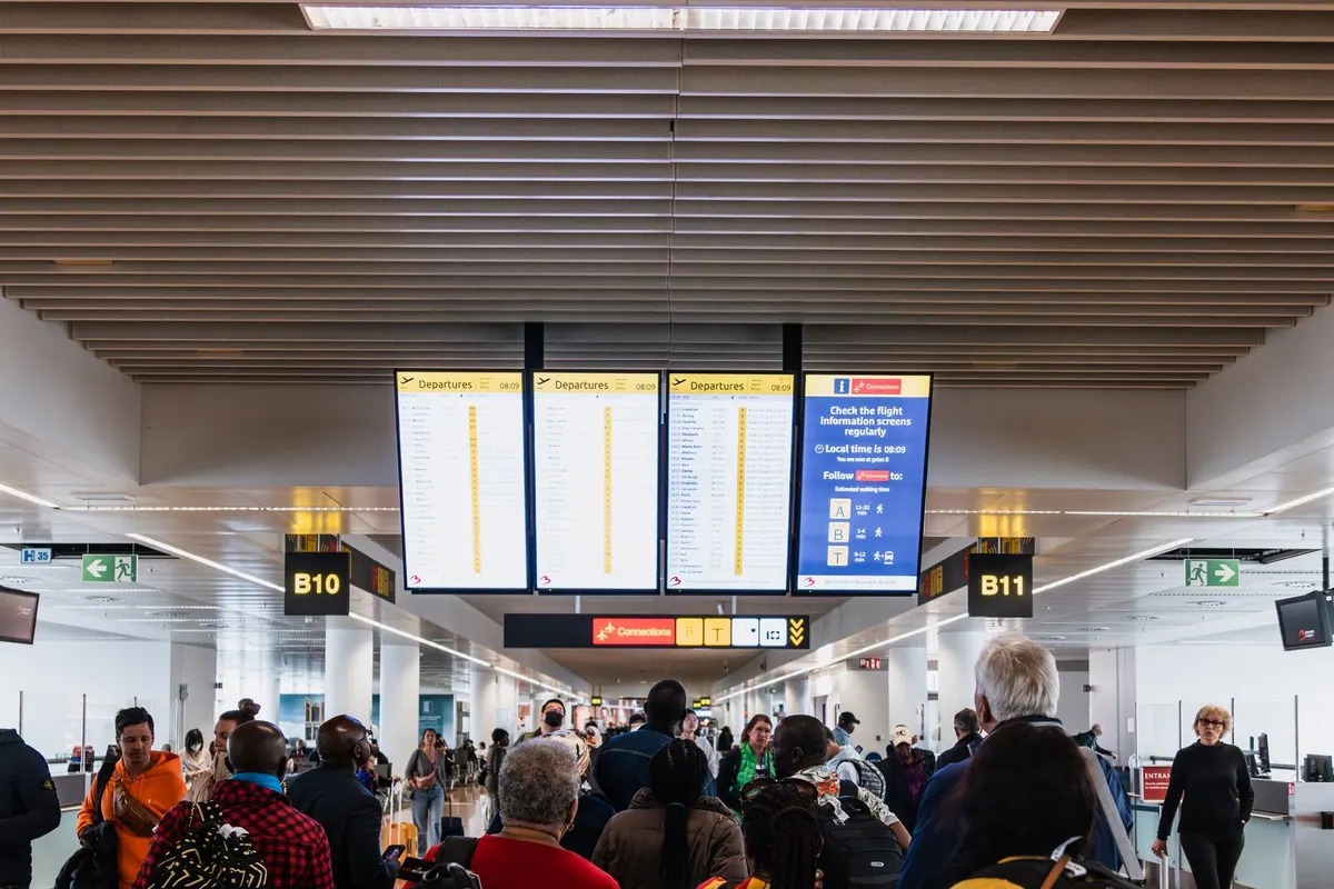 Travellers under the departures boards at a major airport