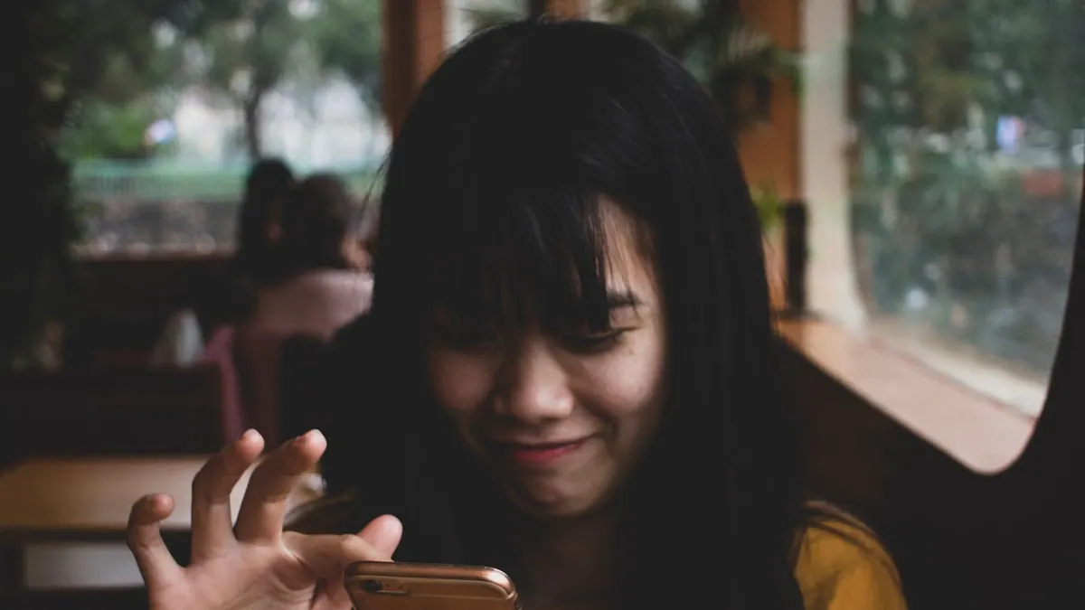 Woman using her phone in a café while travelling