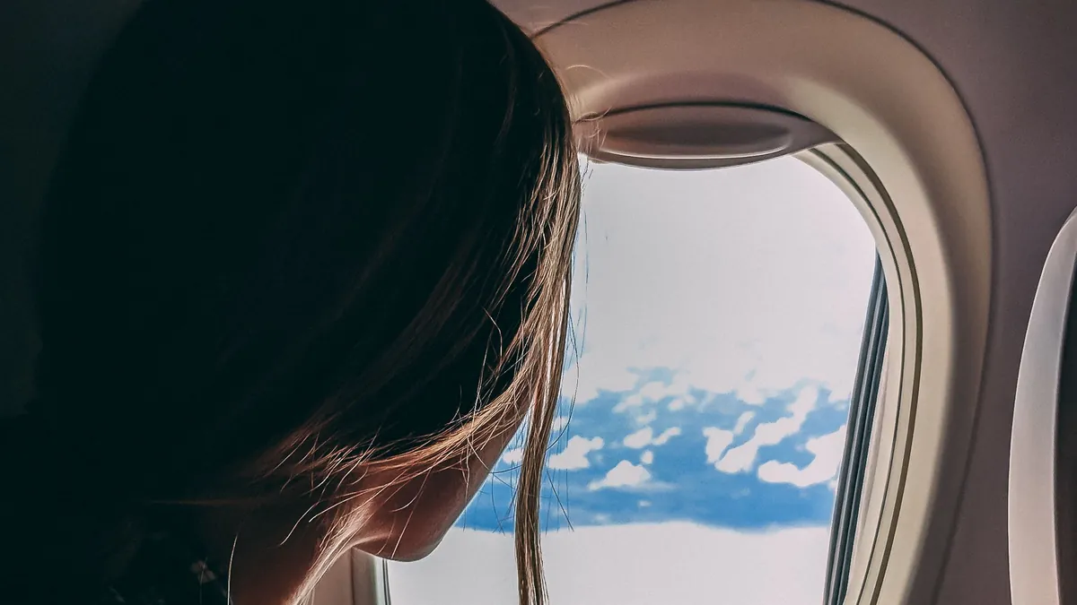Passenger looking out of an aeroplane window in flight